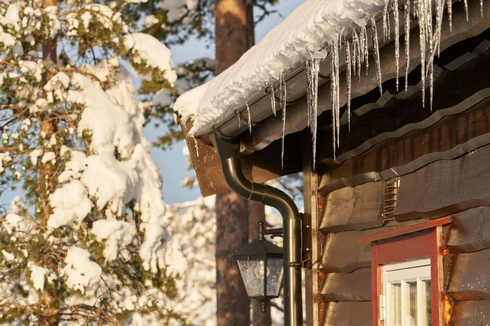 Gouttière chargée de neige et de stalactites de glace