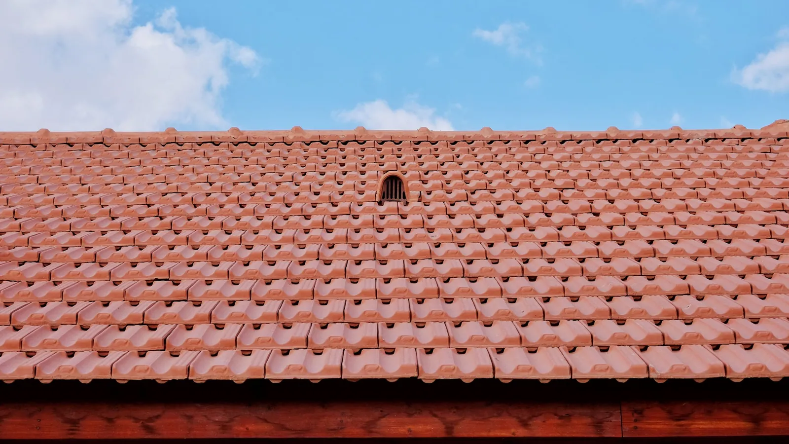 Toiture en tuiles rouges sous un ciel bleu